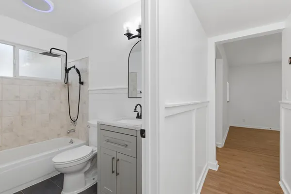 a bathroom with a granite countertop toilet a sink and a bathtub