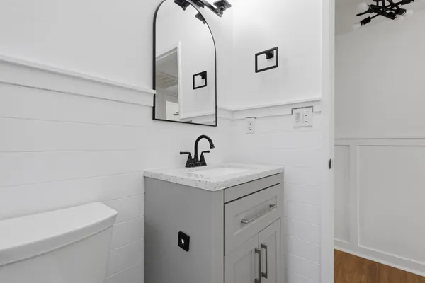a bathroom with a toilet sink and mirror