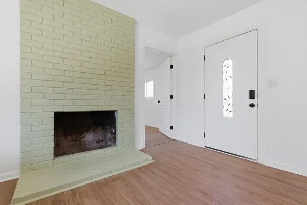 a view of empty room with wooden floor and fireplace