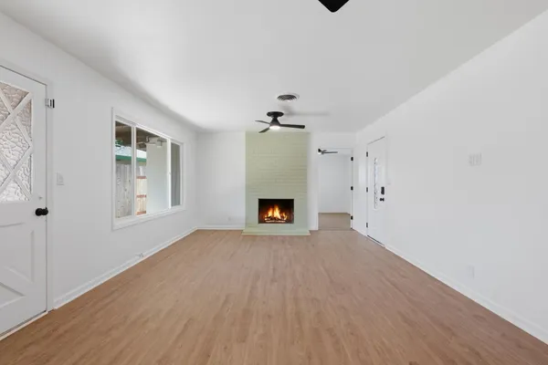a view of an empty room with a fireplace and a window