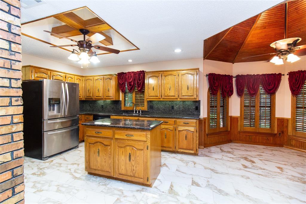 3014 Pecan Ridge Drive Rowlett, TX 75088 - Photo 6 of 29 a kitchen with stainless steel appliances kitchen island granite countertop a refrigerator a sink dishwasher a dining table and chairs with wooden floor