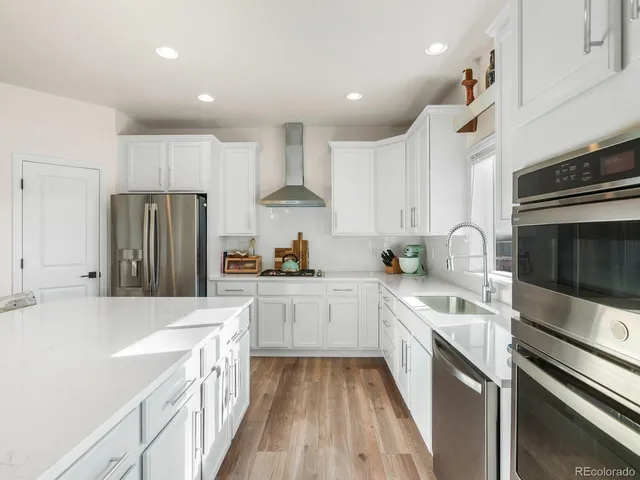 a kitchen with a sink a counter top space stainless steel appliances and cabinets