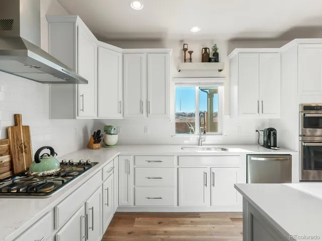 a kitchen with white cabinets and appliances