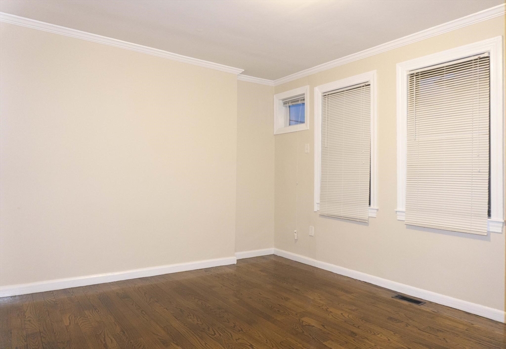 75 Elm Street Watertown, MA 02472 - Photo 7 of 12 an empty room with wooden floor and windows