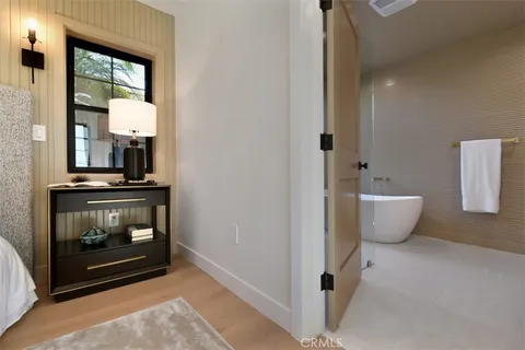 a bedroom with a bed and wooden floor