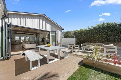 a view of a patio with table and chairs with wooden floor and fence