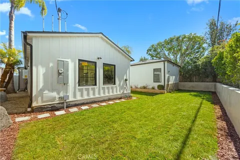 a view of backyard of house with outdoor seating and green space