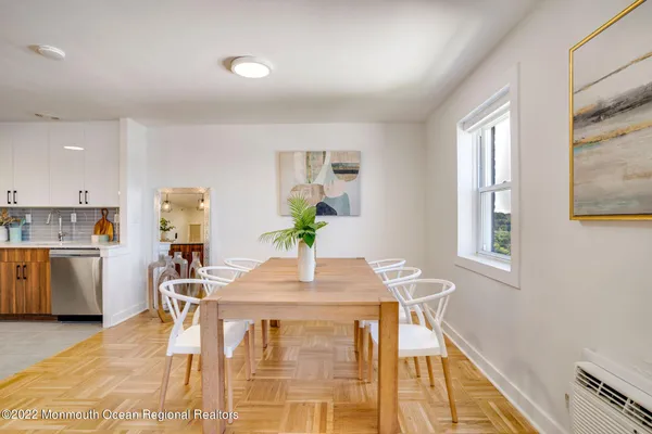 a kitchen that has a lot of white cabinets and stainless steel appliances