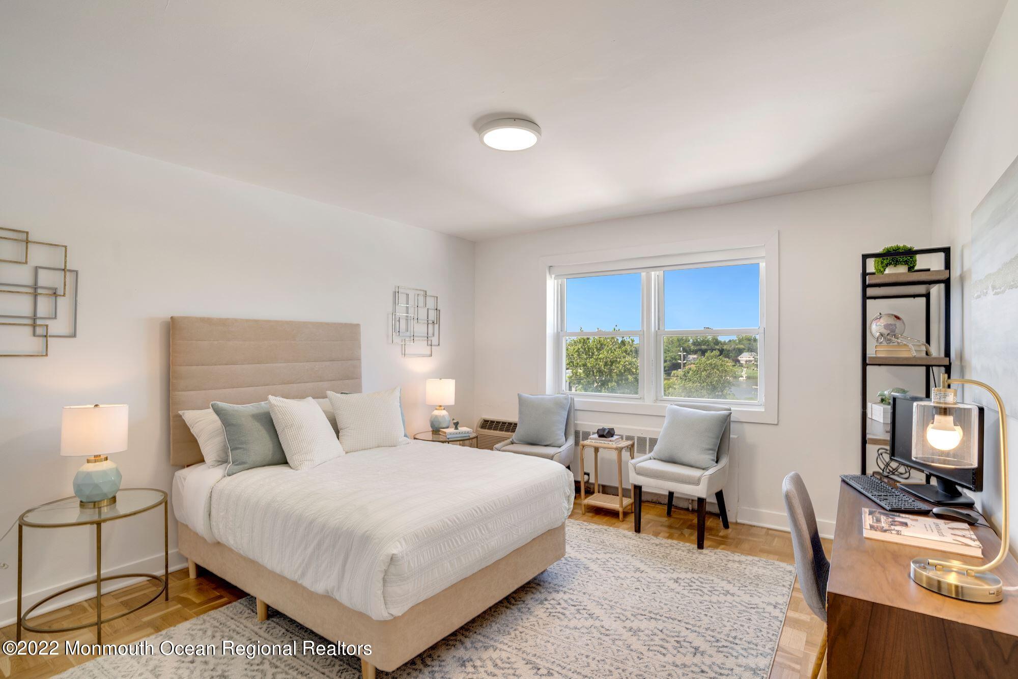 122 Bodman Place, Unit B5 Red Bank, NJ 07701 - Photo 22 of 29 a bedroom with a bed a large window and chair