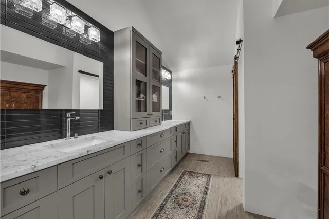 a spacious bathroom with double vanity and a mirror