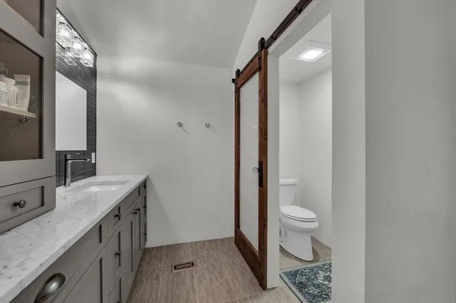 a bathroom with a sink a toilet a mirror and shower