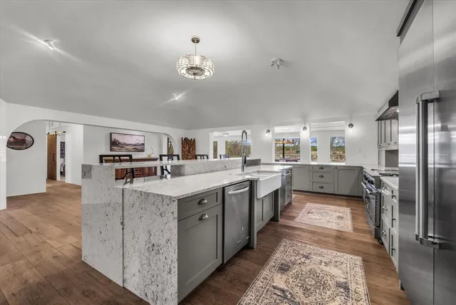 a kitchen with stainless steel appliances white cabinets and a stove top oven