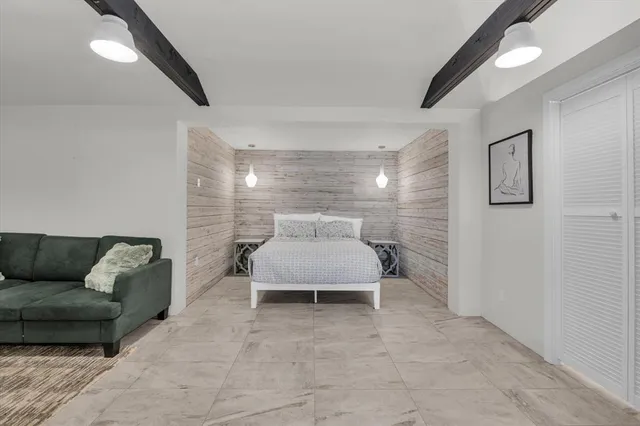 a bedroom with a bed and a dresser with mirror