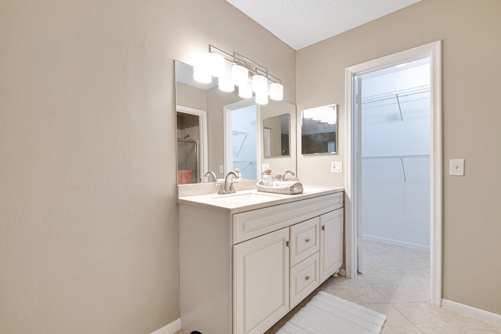 2411 Papaya Drive, Unit 202 Delray Beach, FL 33445 - Photo 15 of 23 a bathroom with a double vanity sink and a mirror with shower