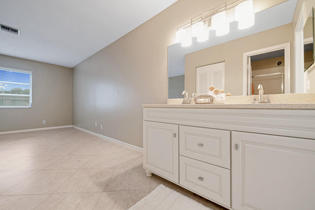 2411 Papaya Drive, Unit 202 Delray Beach, FL 33445 - Photo 16 of 23 a bathroom with a sink vanity and mirror