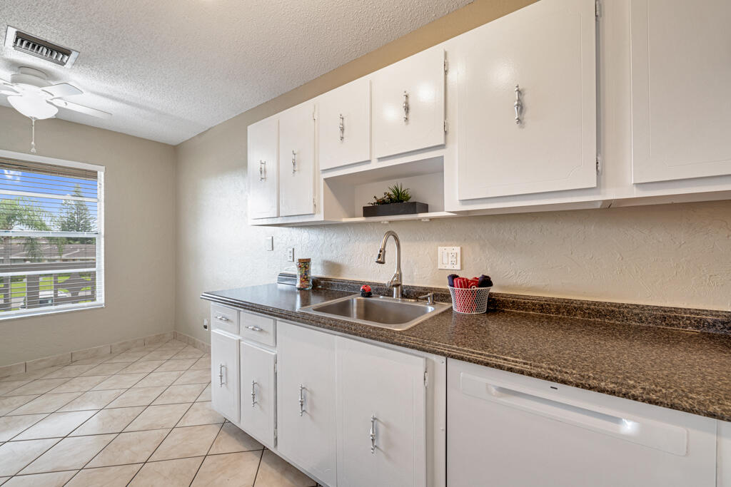 2411 Papaya Drive, Unit 202 Delray Beach, FL 33445 - Photo 4 of 23 a kitchen with stainless steel appliances granite countertop a sink stove and cabinets