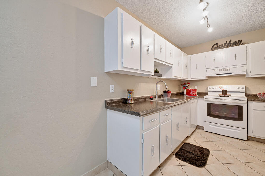 2411 Papaya Drive, Unit 202 Delray Beach, FL 33445 - Photo 5 of 23 a kitchen with stainless steel appliances granite countertop a sink and cabinets