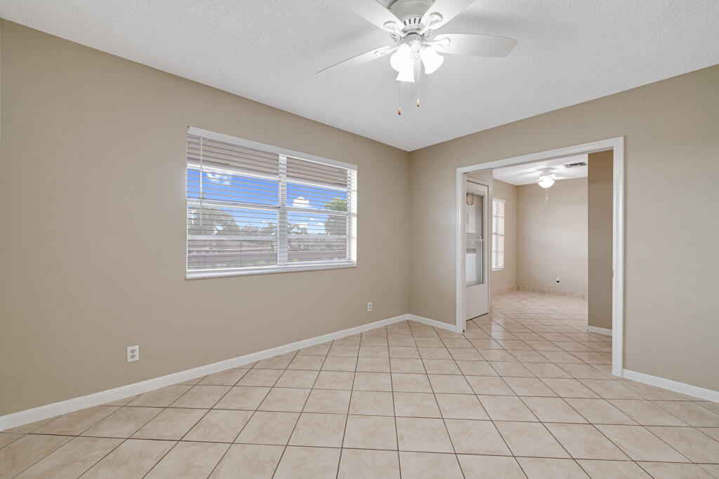 2411 Papaya Drive, Unit 202 Delray Beach, FL 33445 - Photo 6 of 23 a view of an empty room with window and chandelier fan