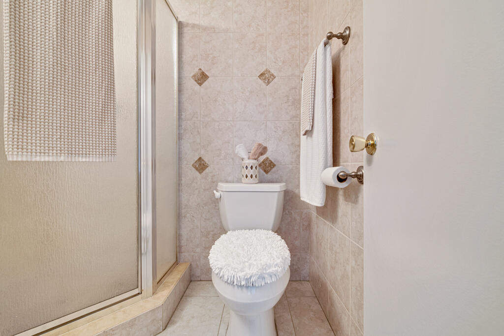 2411 Papaya Drive, Unit 202 Delray Beach, FL 33445 - Photo 8 of 23 a bathroom with a toilet a sink and a shower