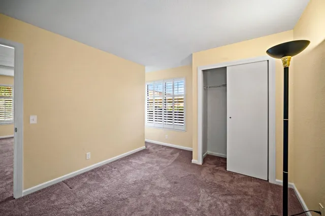 an empty room with closet and a window