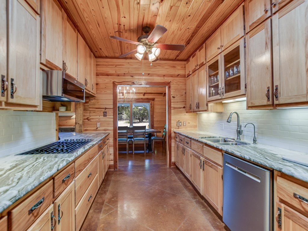 254 Middleton Road Spicewood, TX 78669 - Photo 8 of 32 a kitchen with stainless steel appliances granite countertop a sink and cabinets