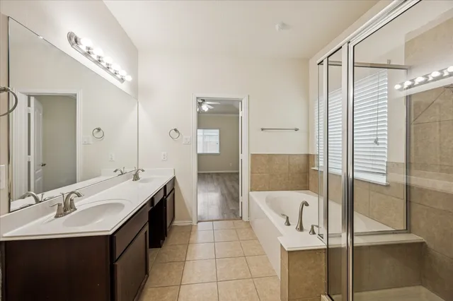 a bathroom with a tub sink shower and two mirror