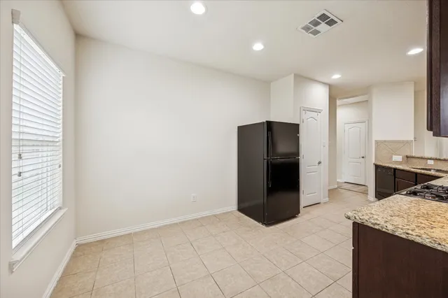 a kitchen with a refrigerator and a stove top oven