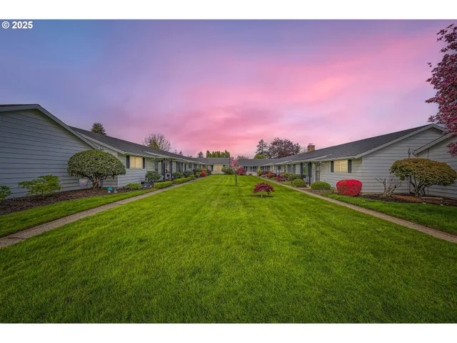 a front view of a house with a yard and potted plants