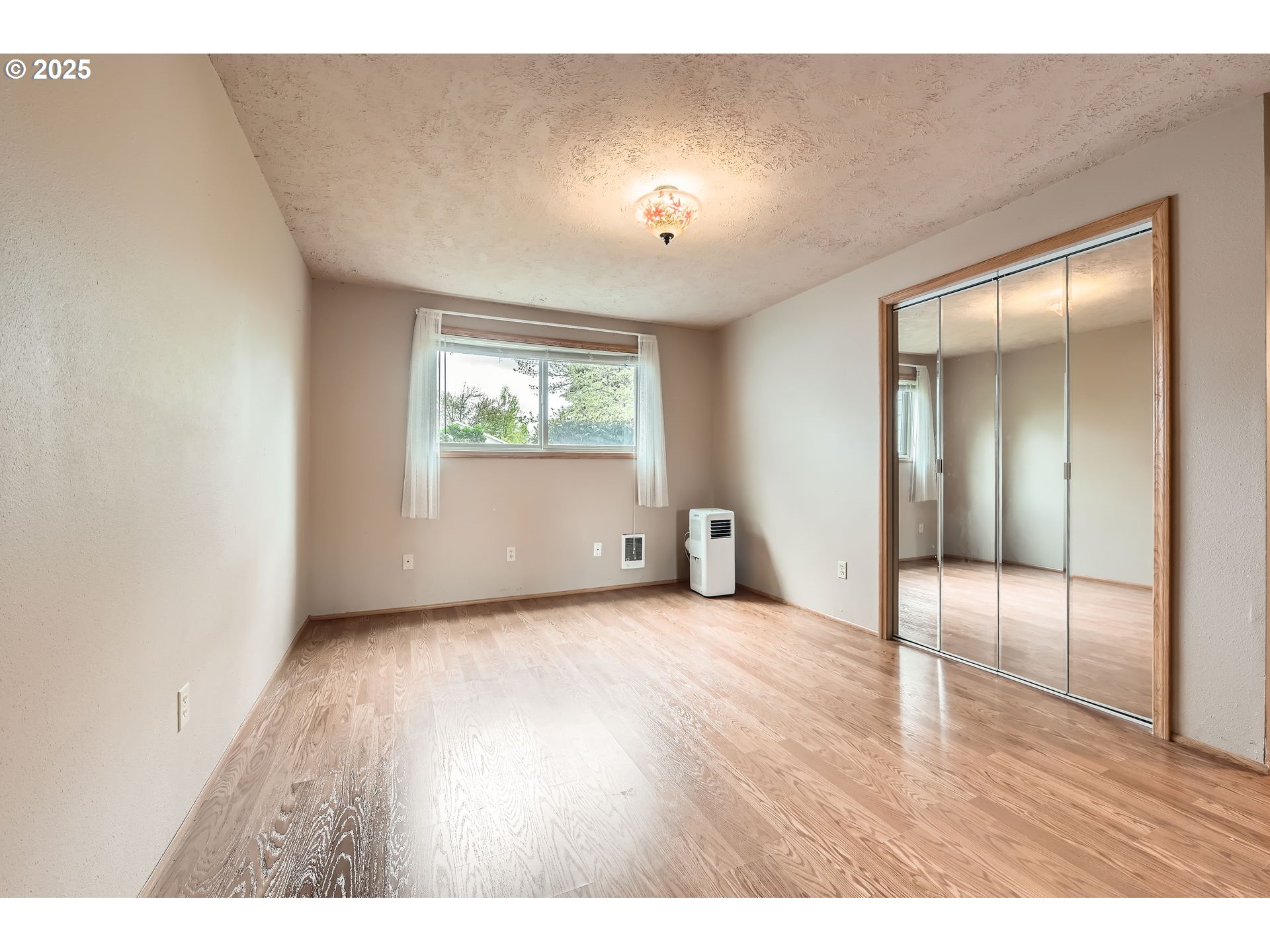 863 Northeast Fleming Avenue, Unit B10 Gresham, OR 97030 - Photo 14 of 38 a view of an empty room with wooden floor and a window
