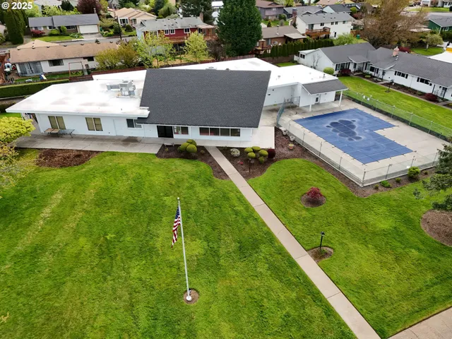 an aerial view of residential houses with outdoor space and trees