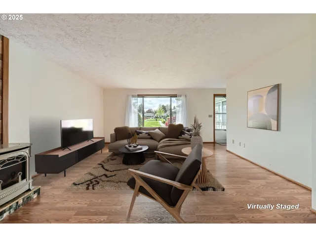a living room with furniture a flat screen tv and a window