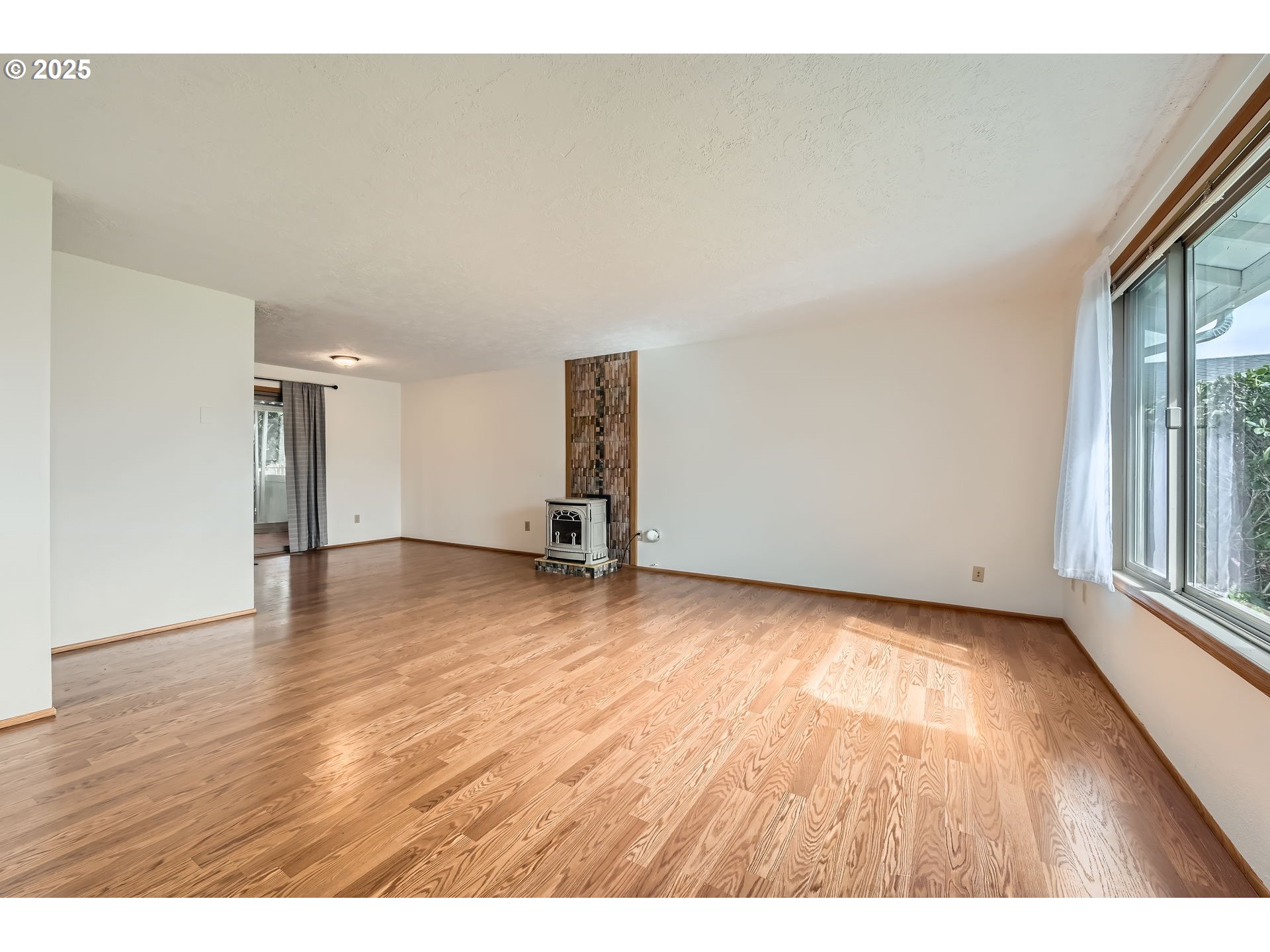 863 Northeast Fleming Avenue, Unit B10 Gresham, OR 97030 - Photo 7 of 38 a view of an empty room with wooden floor and a window