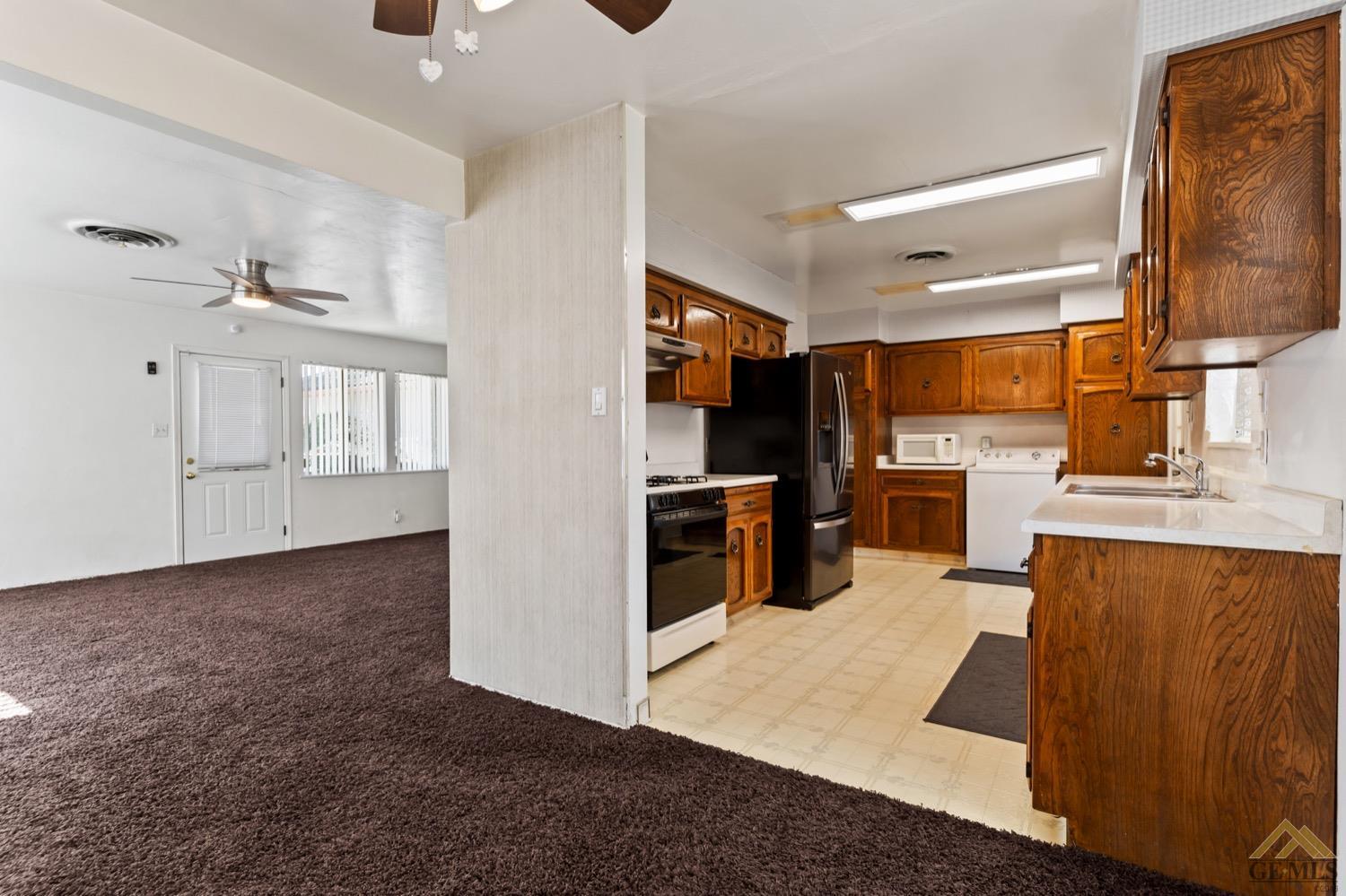 Undisclosed Address Bakersfield, CA 93304 - Photo 10 of 30 a kitchen with stainless steel appliances kitchen island granite countertop a refrigerator oven a sink with dishwasher and white cabinets