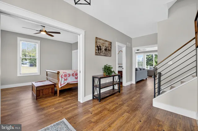 a view of a livingroom with a rug a ceiling fan and wooden floor