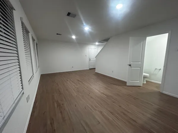 an empty room with wooden floor and white walls