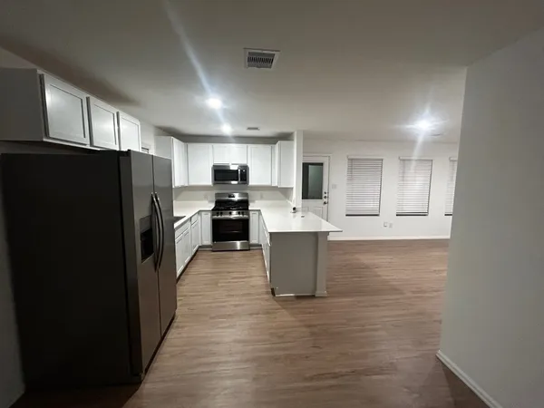 a kitchen with a refrigerator sink and cabinets