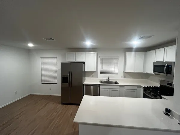 a kitchen with a refrigerator a stove top oven a sink and cabinets