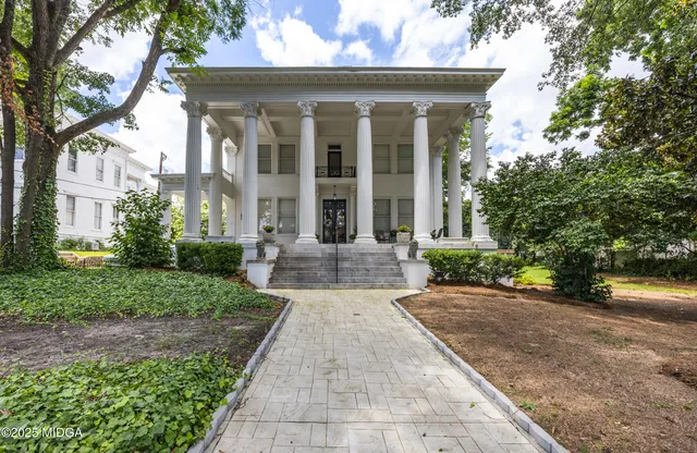a front view of a house with a yard and potted plants