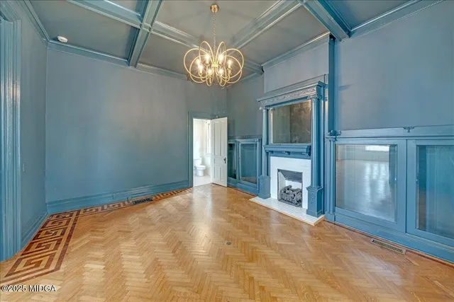 a view of a livingroom with a chandelier fan and kitchen view