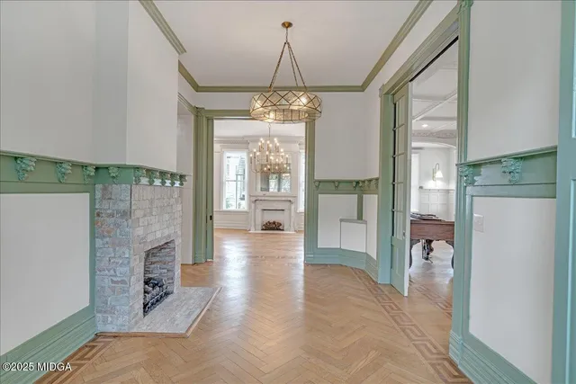 a view of an empty room with wooden floor and a fireplace