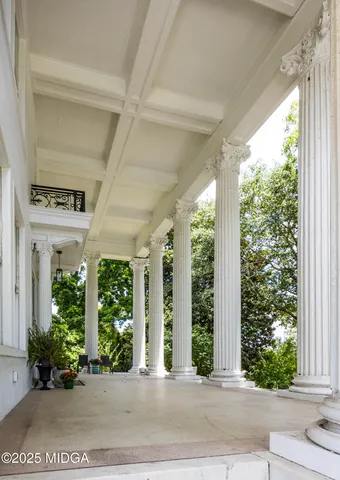a view of a hallway with wooden floor and a living room