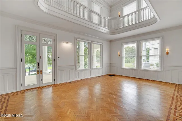 a view of a hallway with wooden floor and a kitchen