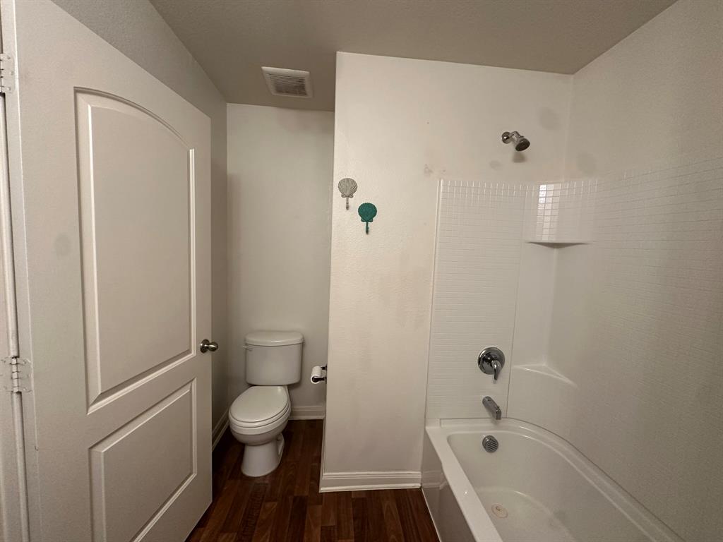 1818 Clegg Street Howe, TX 75459 - Photo 9 of 34 Bathroom featuring a white bathtub and shower combination, chrome fixtures, and a white toilet