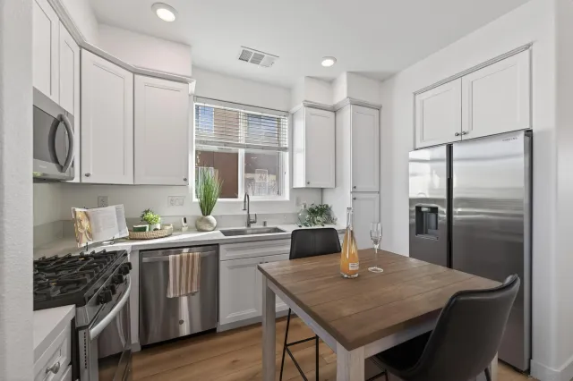 a view of a patio with table and chairs with wooden floor and fence