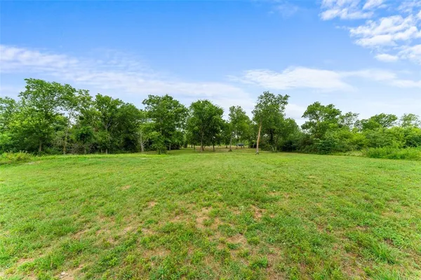 a view of a green field with wooden fence
