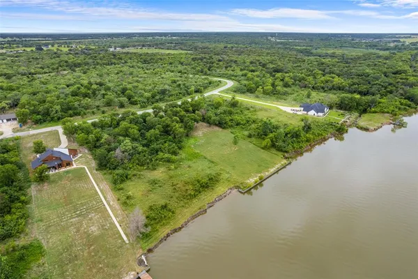 a view of a lush green forest with a lake