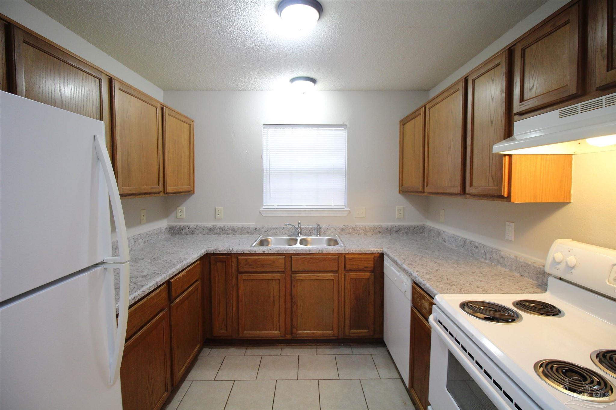 7135 Pearson Road, Unit 7 Pensacola, FL 32526 - Photo 7 of 14 a kitchen with a sink stove top oven and cabinets