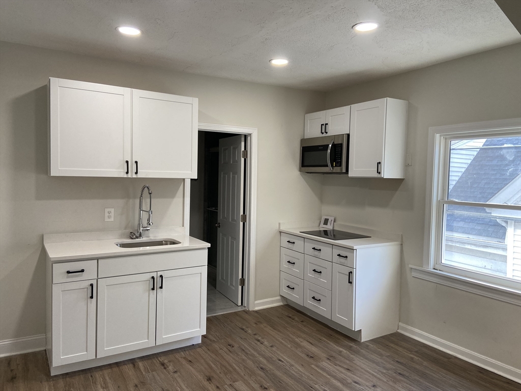 a kitchen with stainless steel appliances granite countertop a sink stove and microwave
