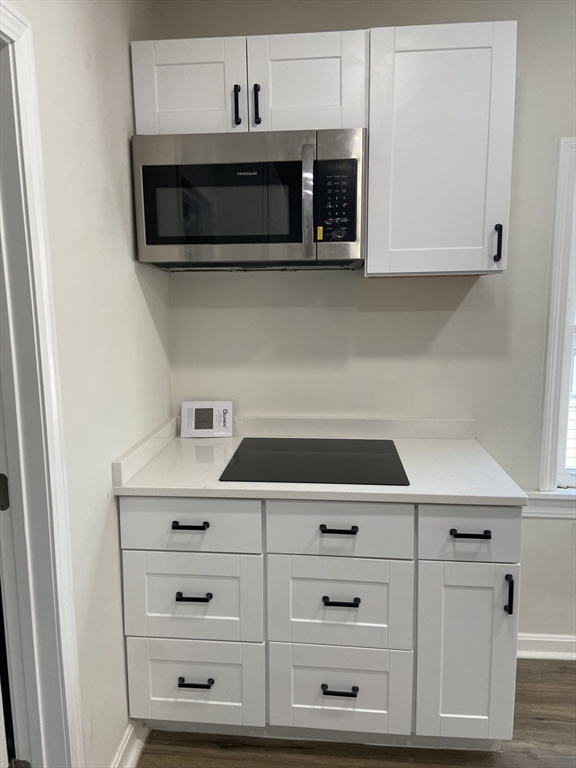 92 South Common Street, Unit 5 Lynn, MA 01902 - Photo 3 of 5 a kitchen with stainless steel appliances white cabinets and a stove a oven with white countertops