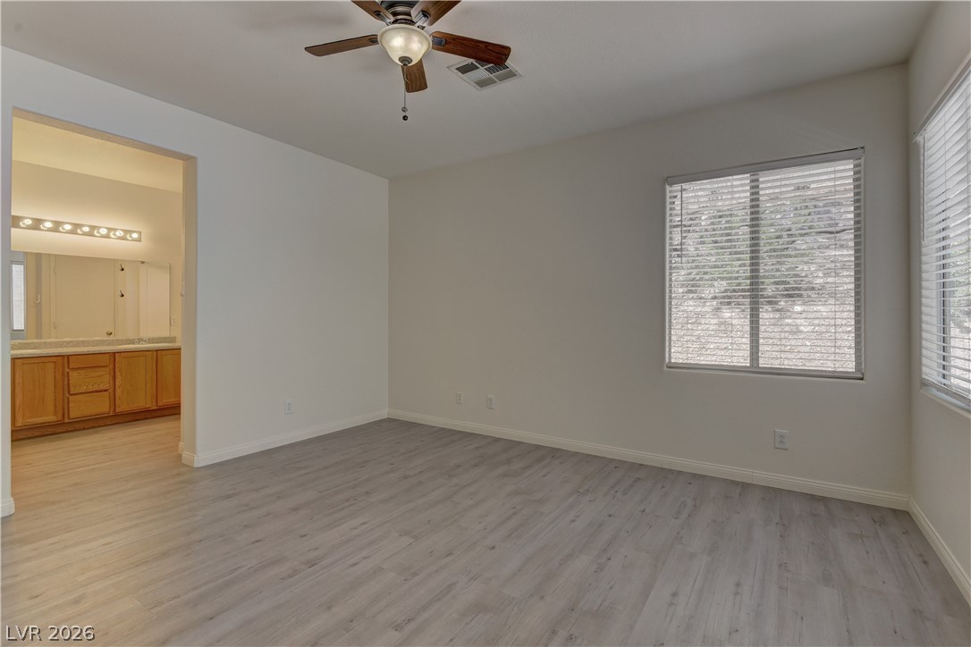 4613 Rising Cove Street Las Vegas, NV 89129 - Photo 10 of 20 This primary bedroom features durable flooring and a private en-suite bathroom for ultimate comfort.